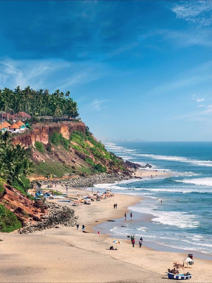 Red laterite cliffs above a wide North Goa beach