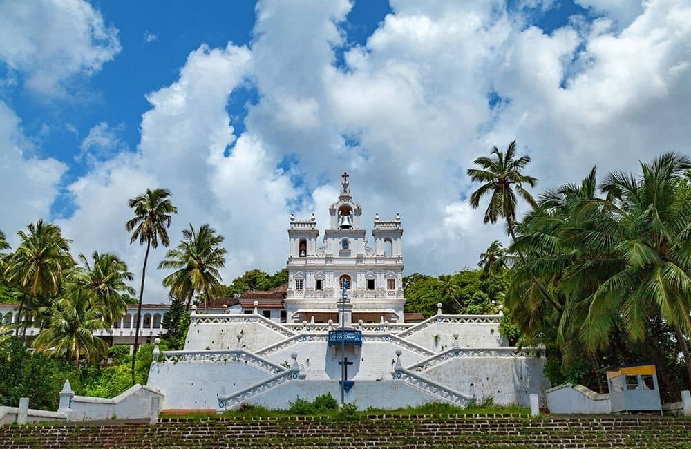A whitewashed Goan church framed by palms
